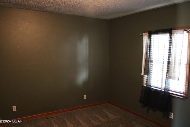 unfurnished room with a textured ceiling and carpet