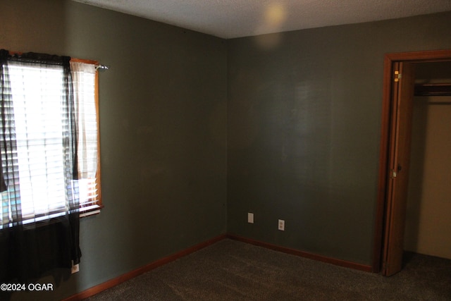 unfurnished bedroom featuring carpet floors, a textured ceiling, and a closet