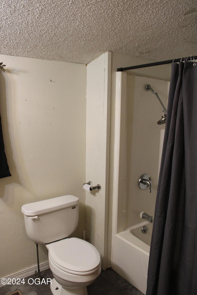 bathroom with a textured ceiling, toilet, and shower / bath combination with curtain