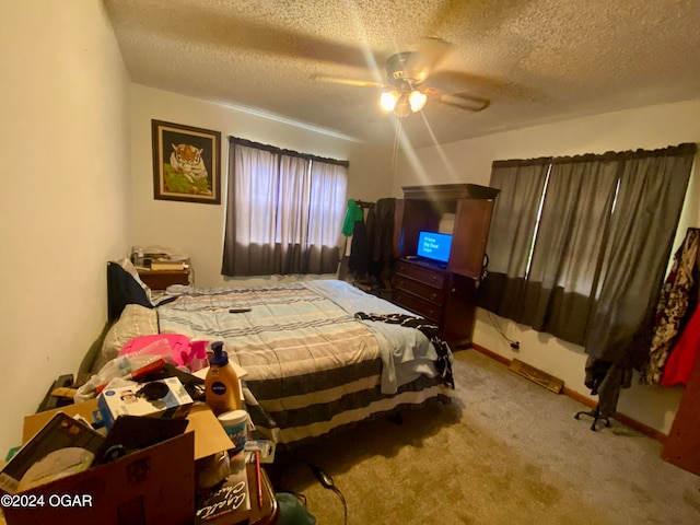 bedroom featuring a textured ceiling, light carpet, and ceiling fan