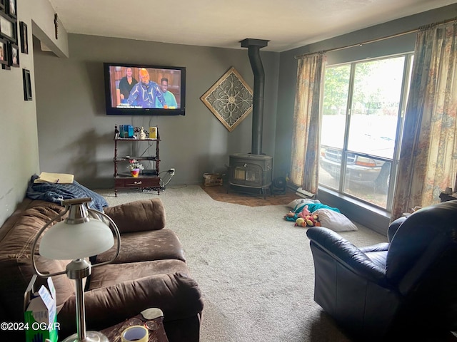 carpeted living room with a wood stove