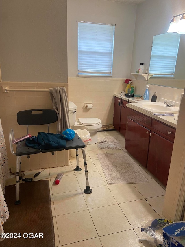 bathroom featuring tile walls, vanity, toilet, and tile patterned floors