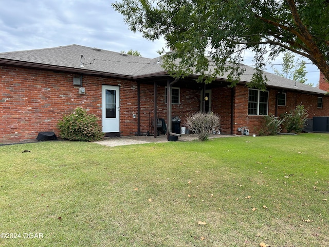 rear view of house featuring a lawn