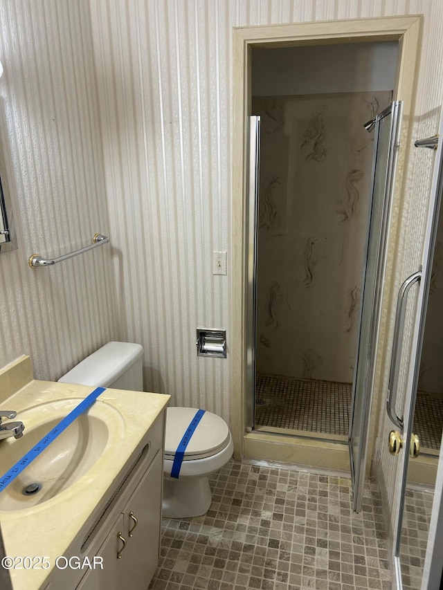 bathroom with vanity, an enclosed shower, and toilet