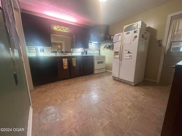 kitchen with a textured ceiling, sink, and white appliances