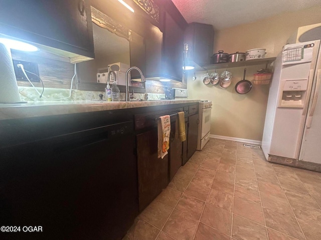 kitchen featuring black dishwasher, a textured ceiling, white refrigerator with ice dispenser, and sink