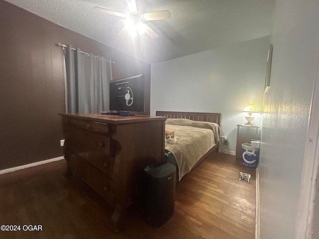 bedroom with ceiling fan, a textured ceiling, and hardwood / wood-style floors