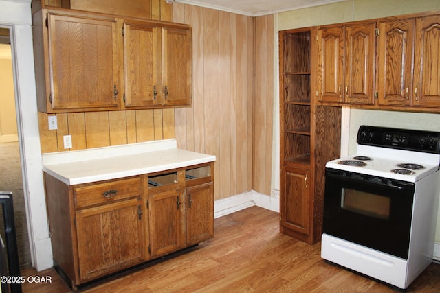 kitchen featuring crown molding, electric range, and light hardwood / wood-style flooring