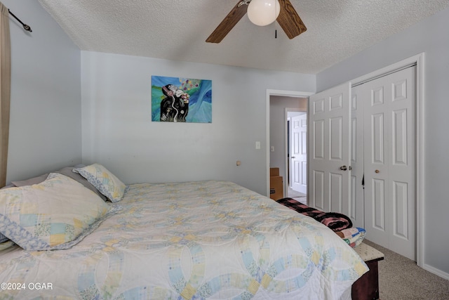 carpeted bedroom with a closet, ceiling fan, and a textured ceiling