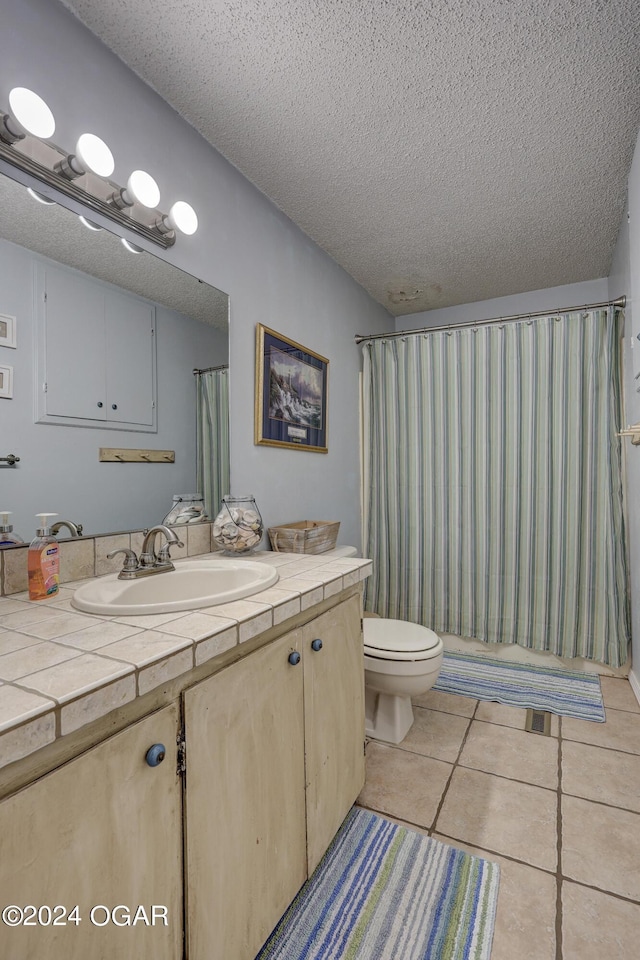 bathroom featuring a textured ceiling, tile patterned flooring, vanity, and toilet