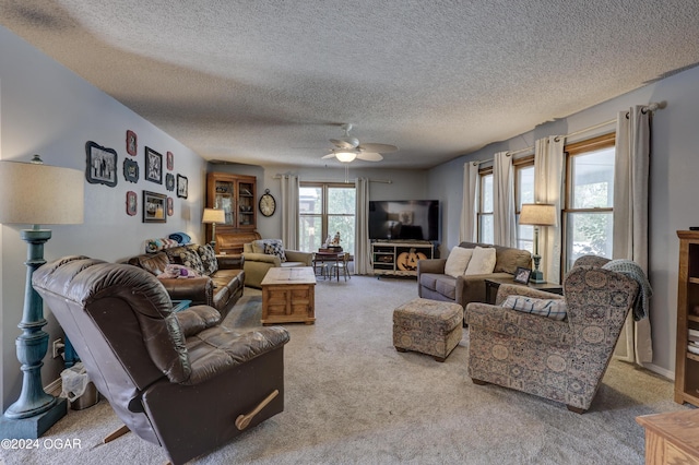 living room featuring ceiling fan, carpet flooring, and a textured ceiling