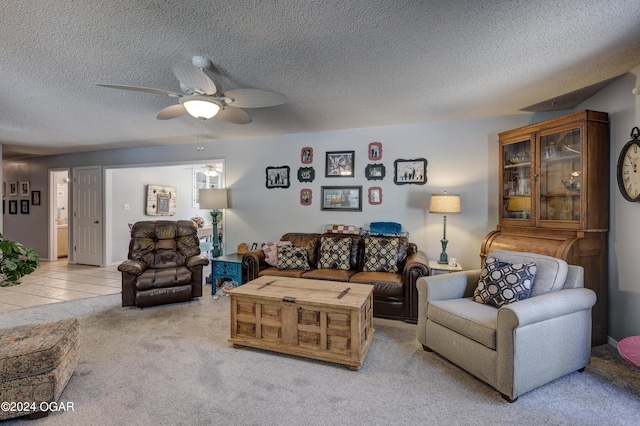 carpeted living room with a textured ceiling and ceiling fan