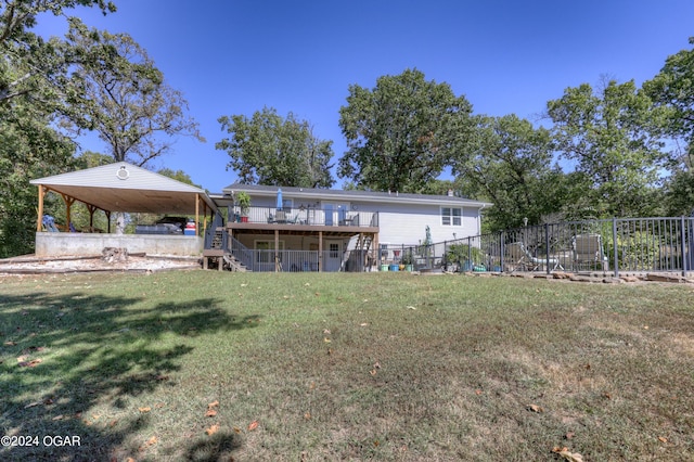 rear view of house featuring a deck and a lawn