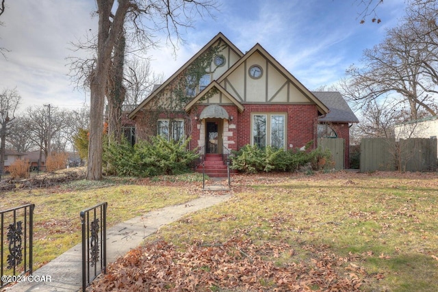 tudor-style house with a front yard