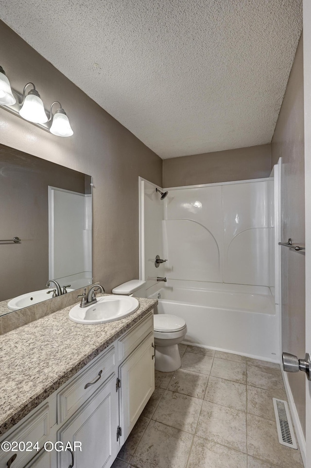 full bathroom with a textured ceiling, toilet, vanity, tile patterned floors, and shower / bath combination