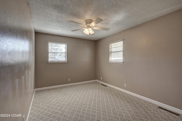 carpeted empty room featuring a textured ceiling and ceiling fan