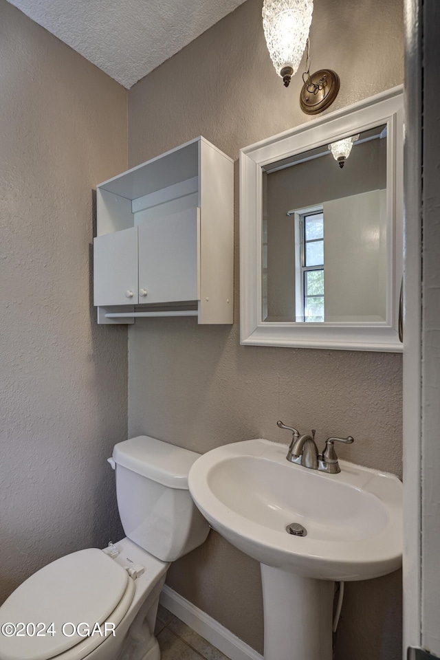 bathroom with sink, a textured ceiling, and toilet