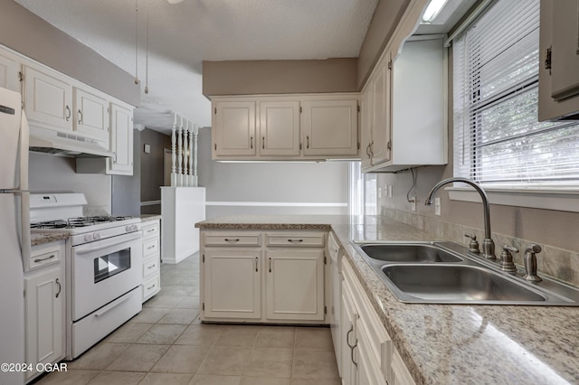 kitchen with white cabinets, a textured ceiling, light tile patterned flooring, sink, and white appliances