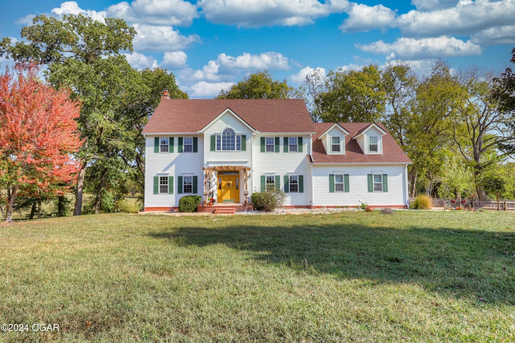 colonial-style house featuring a front yard