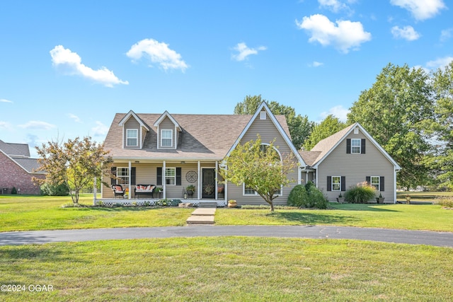 new england style home featuring a front yard and covered porch