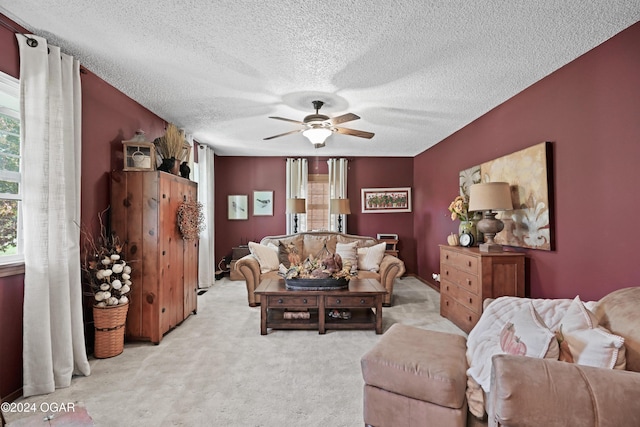 carpeted living room with ceiling fan and a textured ceiling