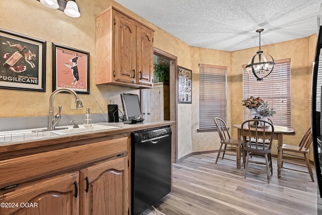 kitchen featuring pendant lighting, a textured ceiling, a chandelier, black dishwasher, and light wood-type flooring