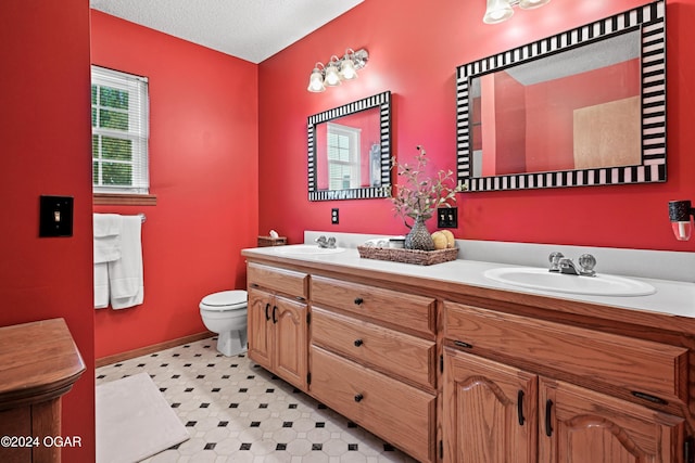 bathroom with vanity, toilet, and a textured ceiling