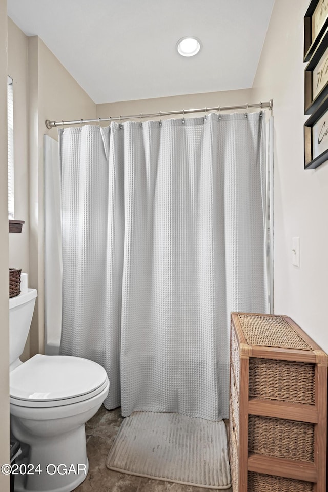 bathroom featuring tile patterned flooring, toilet, and a shower with curtain