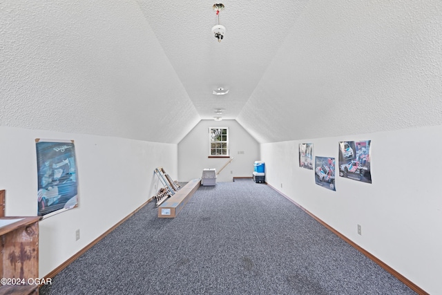 interior space featuring carpet floors, a textured ceiling, and vaulted ceiling