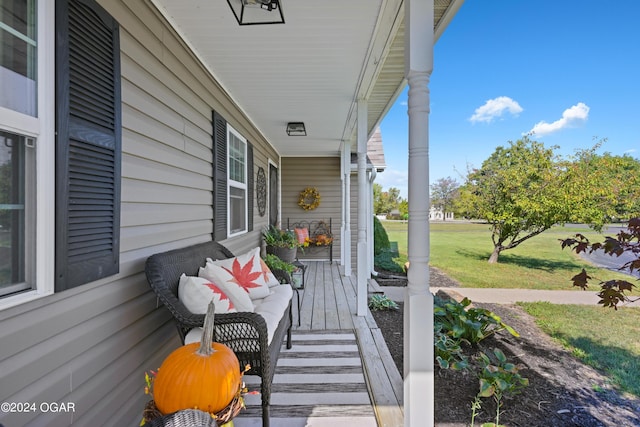 wooden terrace featuring a yard and a porch