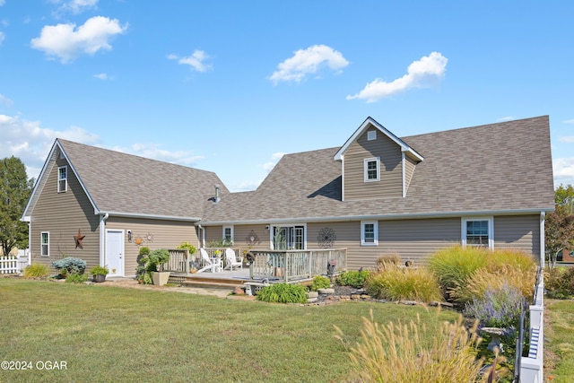 rear view of house featuring a lawn and a deck