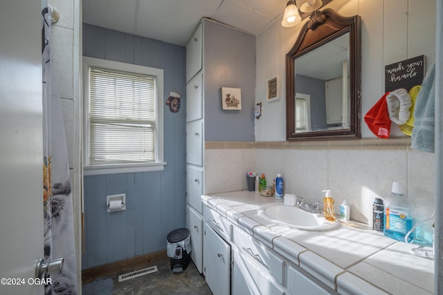 bathroom with wood walls and vanity