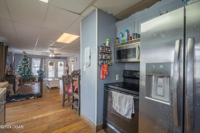 kitchen with a paneled ceiling, ceiling fan, wood-type flooring, and stainless steel appliances