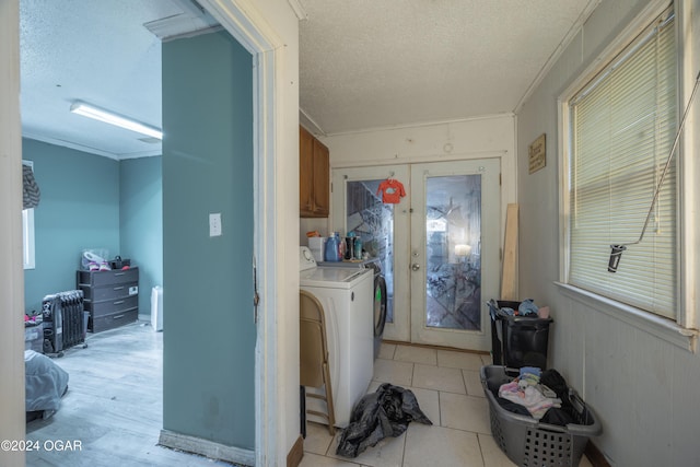 clothes washing area featuring french doors, cabinets, crown molding, a textured ceiling, and washer / dryer