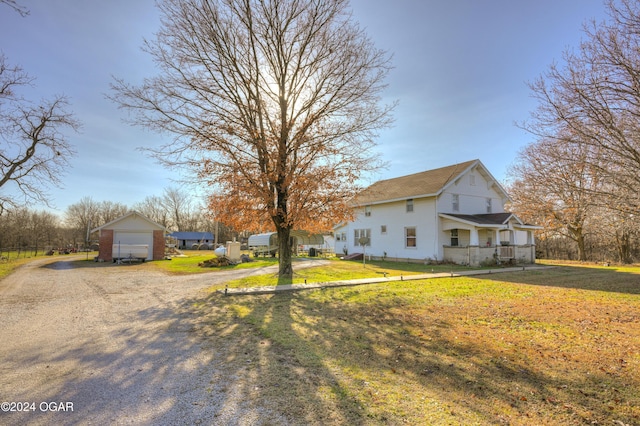 view of side of property with a lawn, a porch, and a garage