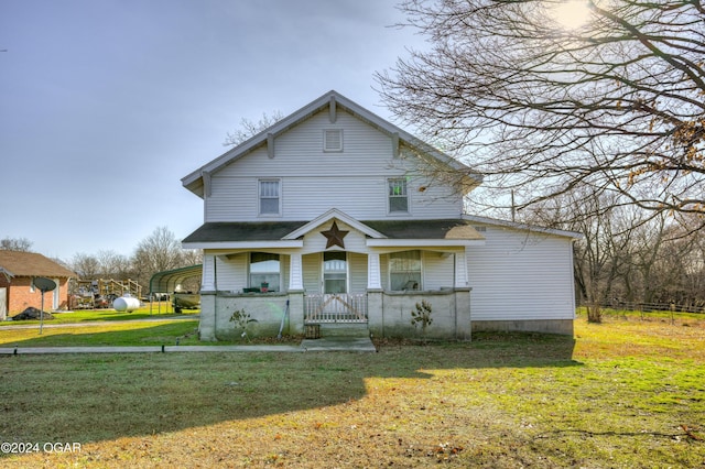 view of front of house featuring a porch, a carport, and a front lawn