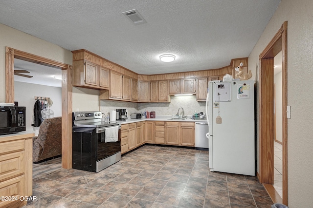 kitchen featuring ceiling fan, light brown cabinets, stainless steel appliances, sink, and a textured ceiling