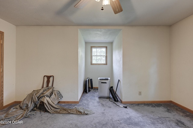 interior space with ceiling fan, a textured ceiling, and carpet flooring