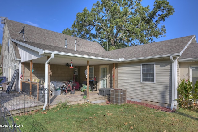 back of property with central AC unit, a lawn, and a patio area