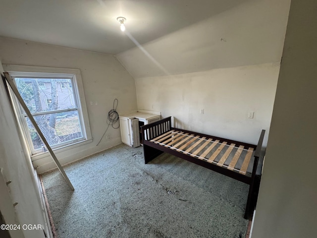 unfurnished bedroom with carpet flooring and vaulted ceiling