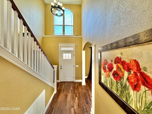 foyer with dark wood-type flooring and a chandelier