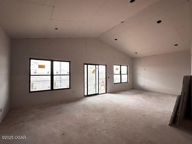 unfurnished room with a healthy amount of sunlight and vaulted ceiling