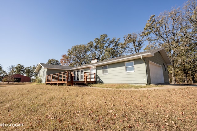 rear view of house featuring a yard and a garage