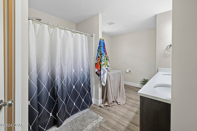 bathroom with vanity, hardwood / wood-style flooring, and walk in shower