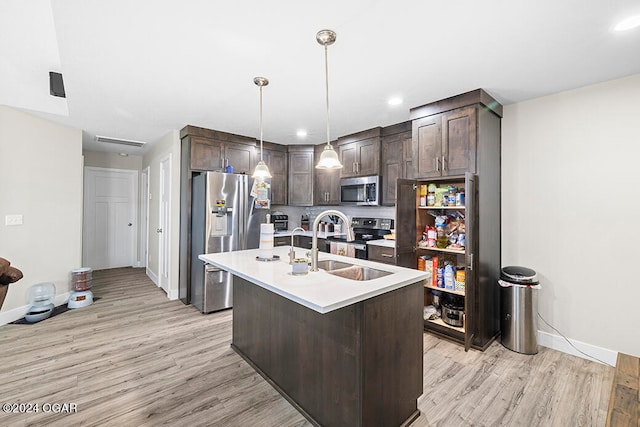 kitchen with light hardwood / wood-style floors, stainless steel appliances, dark brown cabinets, and an island with sink