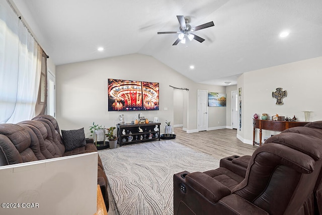 living room featuring ceiling fan, hardwood / wood-style flooring, and vaulted ceiling