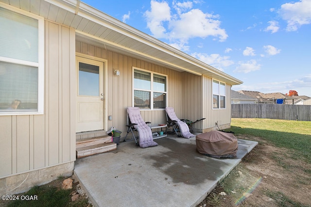 property entrance featuring a patio area and a lawn