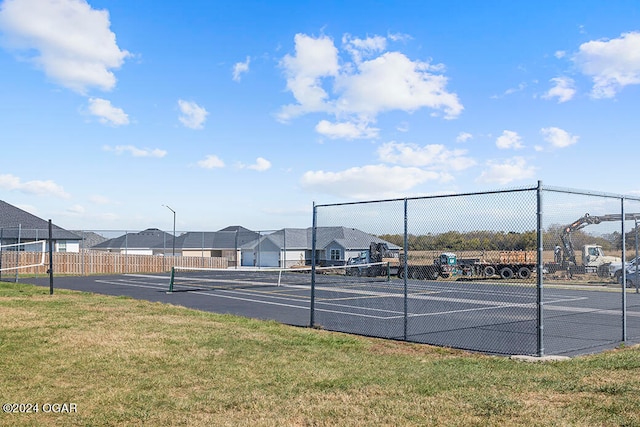 view of sport court with a lawn