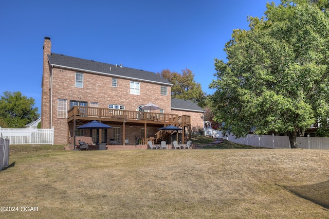 back of property with a wooden deck, a patio area, and a yard