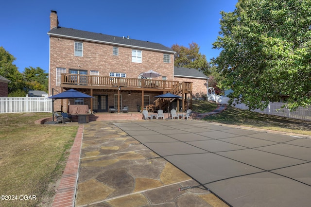 back of property featuring a patio, a deck, and a yard